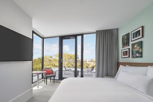 a hotel room with a bed and a balcony at Element Melbourne Richmond in Melbourne