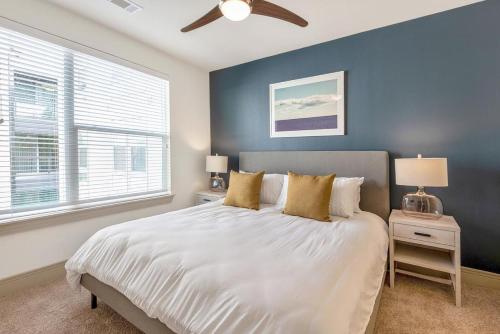 ein Schlafzimmer mit einem weißen Bett und einer blauen Wand in der Unterkunft Landing at 99 Front - 2 Bedrooms in Downtown Memphis in Memphis