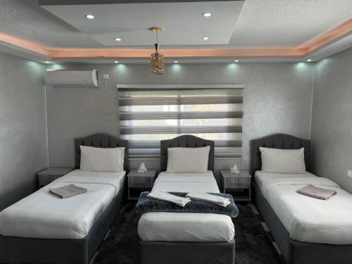 Habitación con 2 camas y toallas. en Petra Pillars Hostel en Wadi Musa