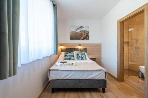 1 dormitorio con 1 cama y baño con ducha en HAPPY domki Zator - 3,5 km Energylandia, en Zator