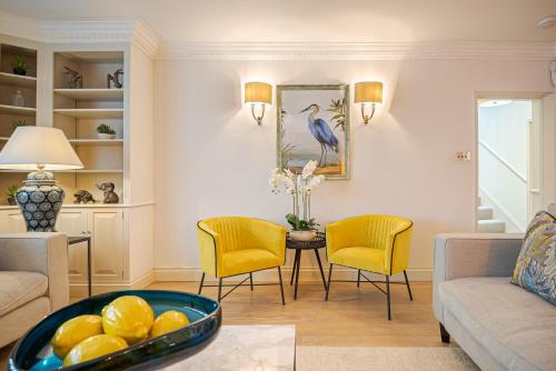 een woonkamer met gele stoelen en een tafel bij 11 Wilton Row in Londen