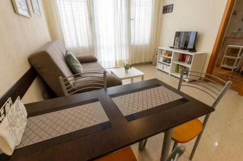 a living room with a table and a couch at Los Hibiscos 406 in Costa Calma