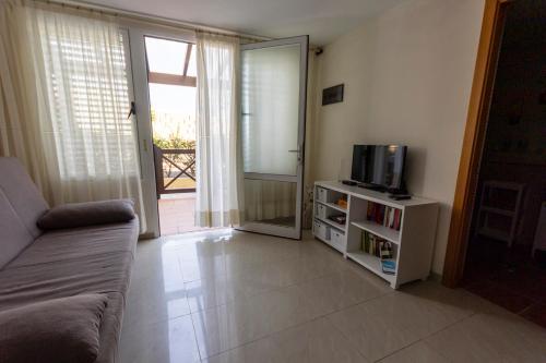 a living room with a couch and a television at Los Hibiscos 406 in Costa Calma