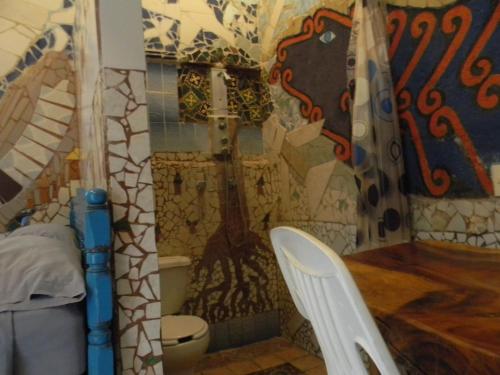 a bathroom with a toilet and a wall with a mural at Casa Vista Al Mar - Iguana Room in Puerto Escondido