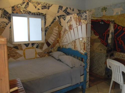 a bedroom with a bed in a room with mosaic walls at Casa Vista Al Mar - Iguana Room in Puerto Escondido