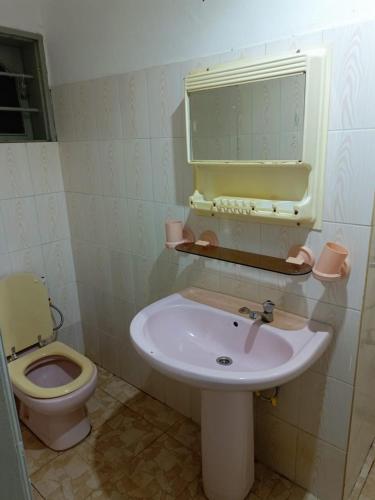 a bathroom with a sink and a toilet at Résidence ABZ Azally in Abomey