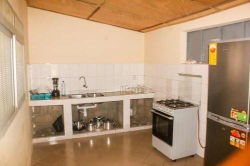 uma cozinha com um lavatório e um fogão em Résidence ABZ Azally em Abomey
