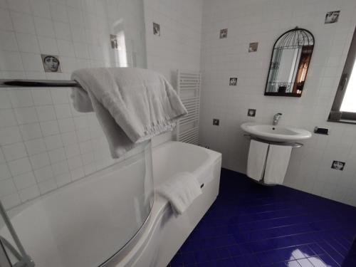 Baño blanco con bañera y lavamanos en Dimora nel Benessere, en Monopoli