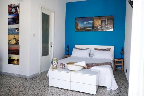 - une chambre bleue avec un lit blanc et un mur bleu dans l'établissement Sikelia Home, à Brucoli