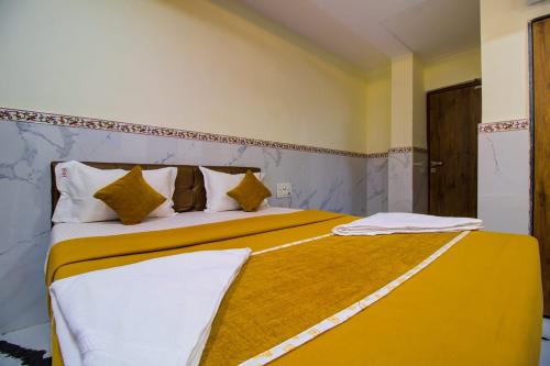 a bedroom with a large bed with yellow and white sheets at Hotel Sai Bansi Residency, MIDC Industrial Area, Turbhe, Navi Mumbai in Mumbai