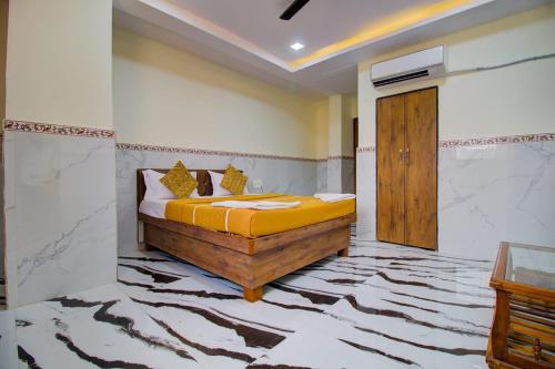 a bedroom with a bed with yellow sheets on it at Hotel Sai Bansi Residency, MIDC Industrial Area, Turbhe, Navi Mumbai in Mumbai