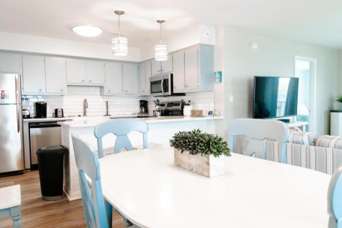 a kitchen with a large white table and chairs at Oceanfront and Modern Top Location on Ocean Blvd w Pool in Myrtle Beach