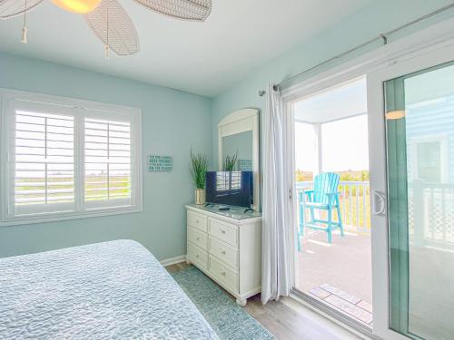 a bedroom with a bed and a television and a balcony at Oceanfront and Modern Top Location on Ocean Blvd w Pool in Myrtle Beach