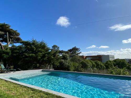 a swimming pool in the yard of a house at House of green leaves in Chelreira