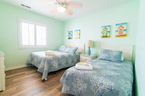 a bedroom with two beds and a ceiling fan at Oceanfront and Modern Top Location on Ocean Blvd w Pool in Myrtle Beach