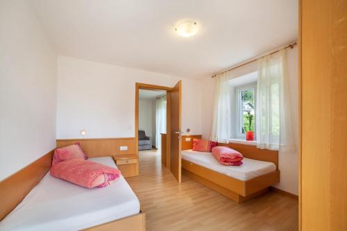 um quarto com 2 camas e uma janela em Mosttragerhof Appartment 1 em Scena