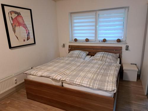 a small bedroom with a bed with a window at Ferienwohnung Kupfer in Niestetal