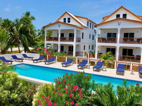 a villa with a swimming pool and a resort at VeLento Beach Level #9 in Caye Caulker