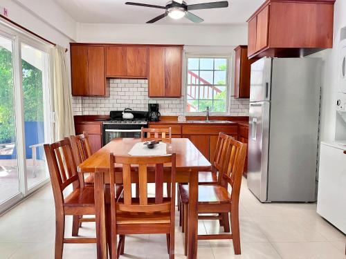 cocina con mesa, sillas y nevera en VeLento Beach Level #9, en Caye Caulker