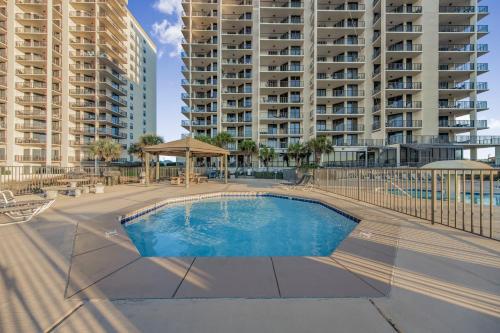 a swimming pool in front of a large apartment building at Phoenix VIII 81201 by Vacation Homes Collection in Orange Beach