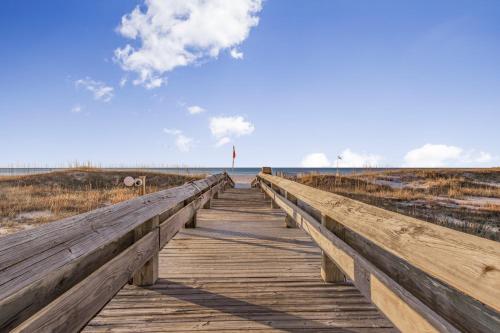 a wooden boardwalk in the middle of the beach at Phoenix VIII 81201 by Vacation Homes Collection in Orange Beach