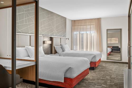 a hotel room with two beds and a mirror at SpringHill Suites by Marriott Menomonee Falls in Menomonee Falls