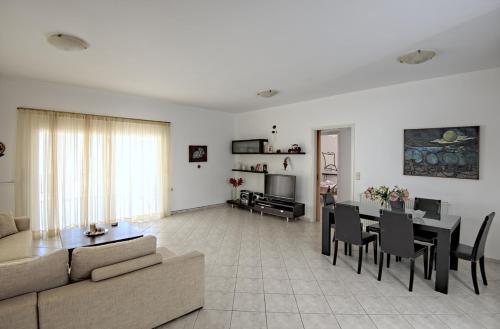 a living room with a couch and a table at Seafront Home Villa in Kato Gouves
