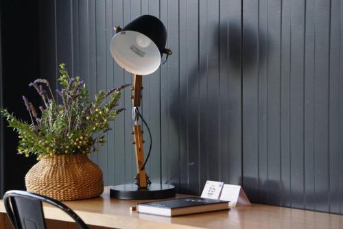 a lamp on a desk with a book and a plant at Viña LOF - Maipo Valley Bed & Breakfast in Winery in Paine