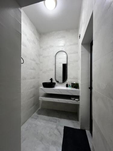 a bathroom with a sink and a mirror at شالية رواء كبلز in á¸¨arÄdÄ«