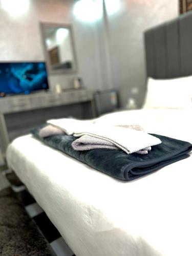 a bed with white sheets and towels on it at Petra Pillars Way Hostel in Wadi Musa