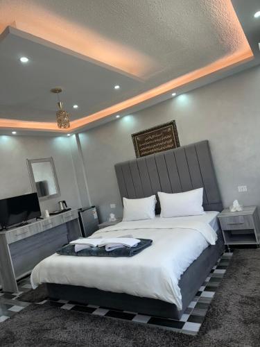 a bedroom with a large bed and a television at Petra Pillars Way Hostel in Wadi Musa