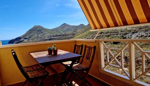 a table and chairs on a balcony with a view of the mountains at Cabo de Palos Apartment in Cabo de Palos
