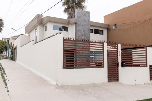 a house with white walls and a fence at Casa Espejos Sauzal with AC and Private Parking in El Suazal
