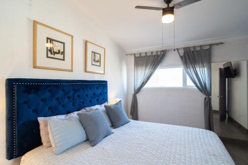 a bedroom with a large bed with a blue headboard at Casa Espejos Sauzal with AC and Private Parking in El Suazal