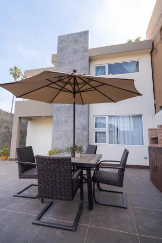 a table and chairs with an umbrella on a patio at Casa Espejos Sauzal with AC and Private Parking in El Suazal