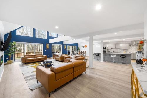 a living room with brown furniture and a kitchen at Big Villa,4 Masters, Heated Pool, Hot Tub, Sauna in Blakeslee