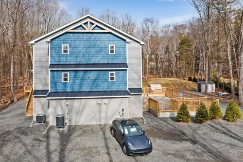 a car parked in front of a blue house at Big Villa,4 Masters, Heated Pool, Hot Tub, Sauna in Blakeslee