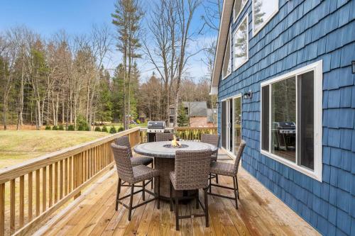 a patio with a table and chairs on a deck at Big Villa,4 Masters, Heated Pool, Hot Tub, Sauna in Blakeslee