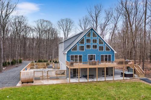a large blue house with a large deck at Big Villa,4 Masters, Heated Pool, Hot Tub, Sauna in Blakeslee