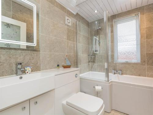 a bathroom with a toilet and a tub and a sink at 4 Bed in Brodick CA381 in Brodick
