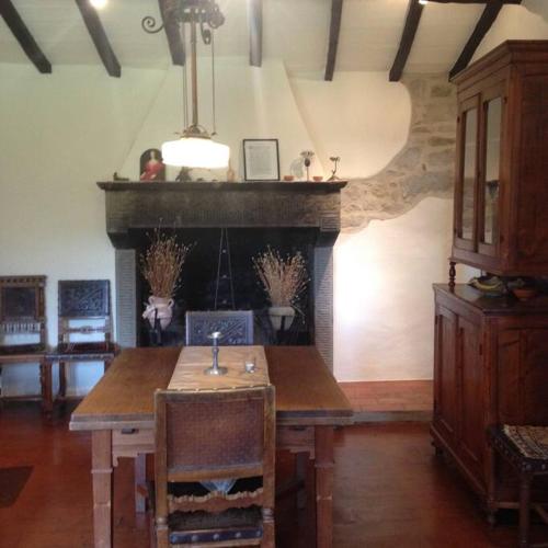 a living room with a fireplace and a table and chairs at Val di Rampo - Appartment with Pool, private terrace overlooking Niccone Valley in Casella