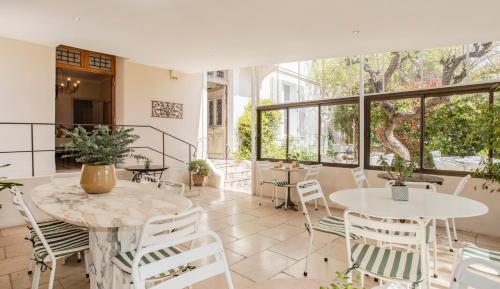 a room with tables and chairs and windows at Hotel La Bienvenue in La Croix-Valmer