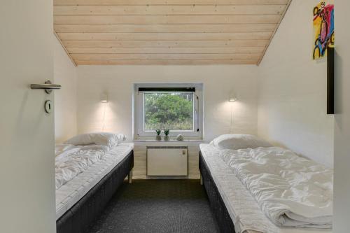 2 Betten in einem Zimmer mit Fenster in der Unterkunft Holiday home with spa and pool by the sea - SJ670 in Harboør
