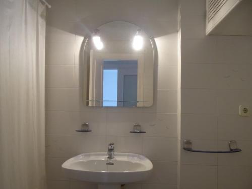 y baño con lavabo y espejo. en Residencial Los Ibicencos V.v., en La Manga del Mar Menor