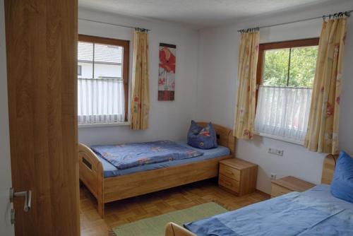 - une chambre avec 2 lits et une fenêtre dans l'établissement Ferienhaus Ziegler, à Loßburg
