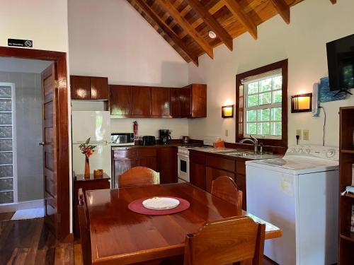 cocina con mesa de madera y comedor en Sea Garden Cottage, en Caye Caulker