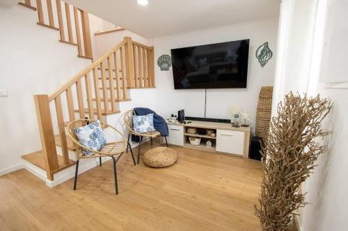 a living room with two chairs and a flat screen tv at NEW! Oceanfront Home with HotTub, Lagoa Sao Miguel Azores in Lagoa
