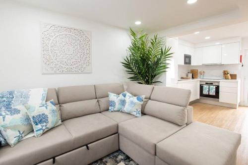 a living room with a couch with pillows at NEW! Oceanfront Home with HotTub, Lagoa Sao Miguel Azores in Lagoa