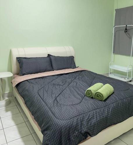 ein Bett mit zwei grünen Handtüchern darüber in der Unterkunft 3Homestay Bentong in Bentong