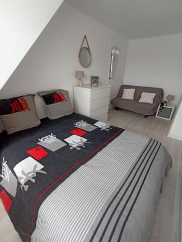 une chambre avec un lit avec une couverture noire et blanche dans l'établissement Charmant duplex, bord de mer, à Merville-Franceville-Plage